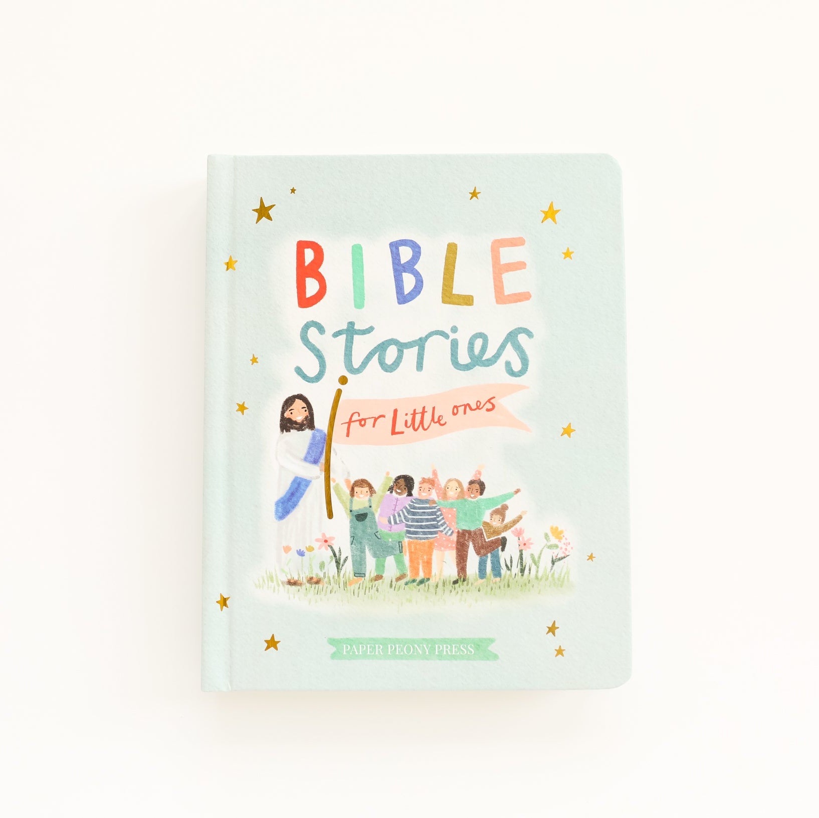 A hardcover book titled 'BIBLE Stories for Little ones' by The Ministry of May, featuring a pastel mint green cover with colorful hand-lettered title text and a whimsical illustration of children and Jesus on a white background.