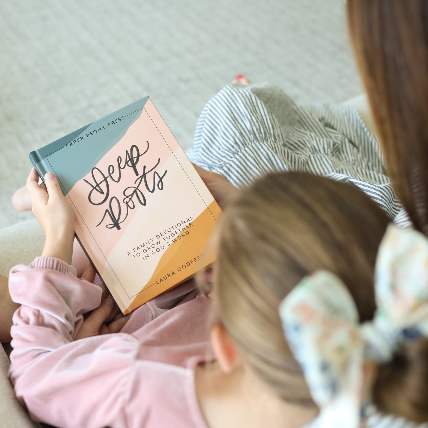 Two people sitting on a couch, each holding a book titled 'Deep Roots'.