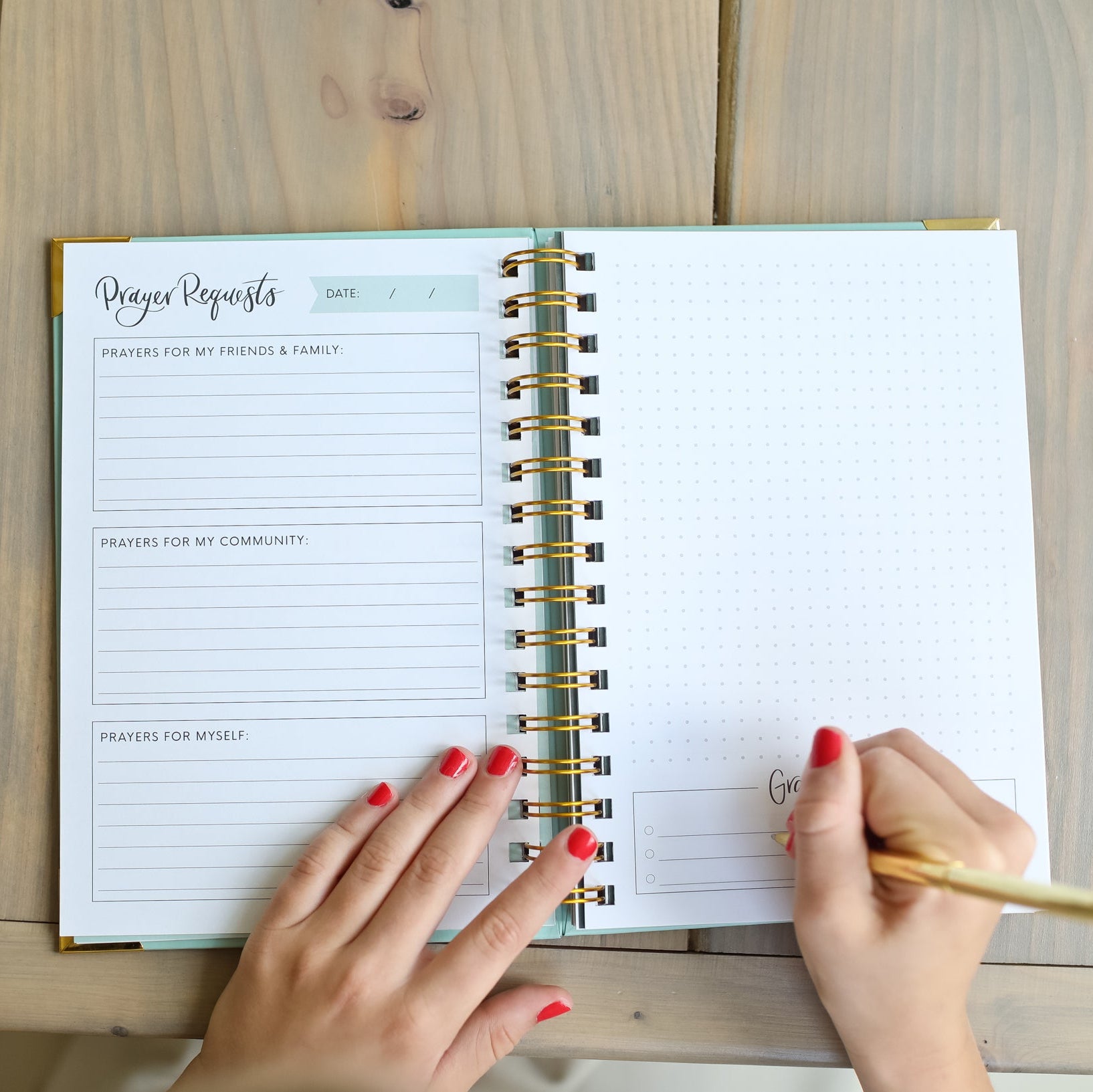 Person writing in a planner on a wooden desk