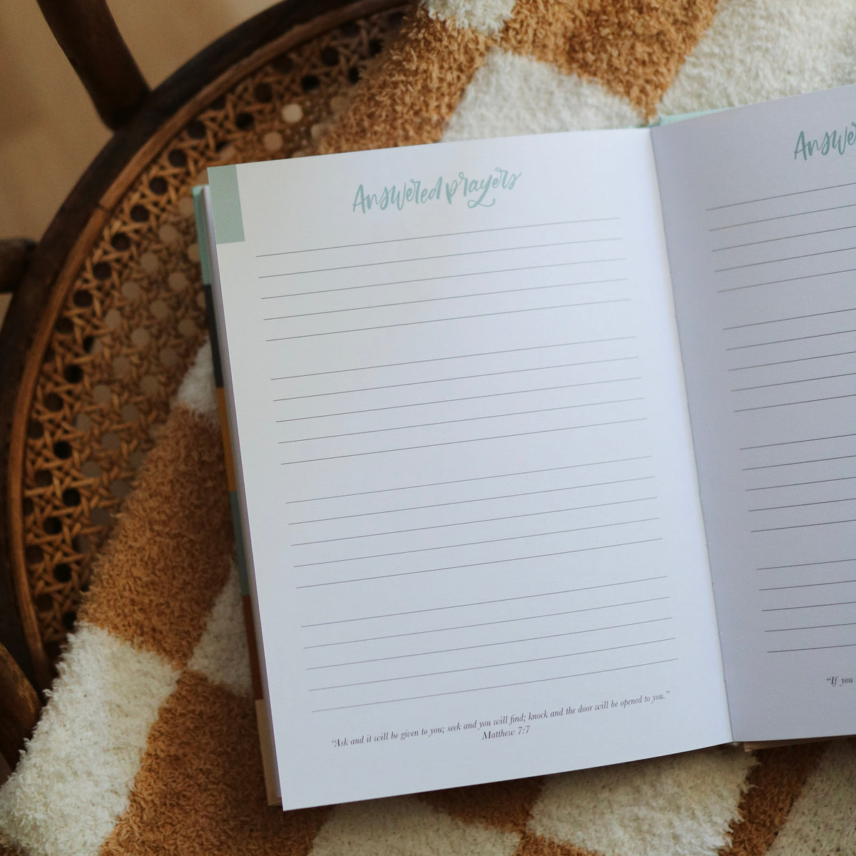 Open notebook on a textured surface with a plant in the corner