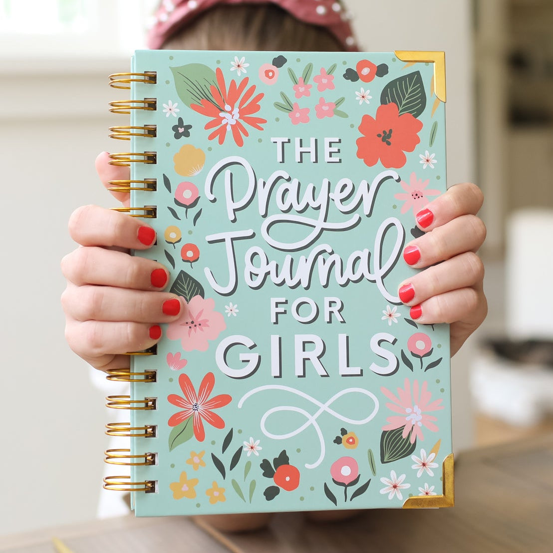 Person holding a 'Prayer Journal for Girls' with floral design