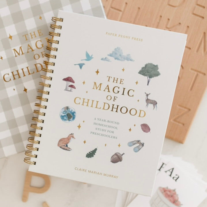 Book titled 'The Magic of Childhood' with educational materials on a surface